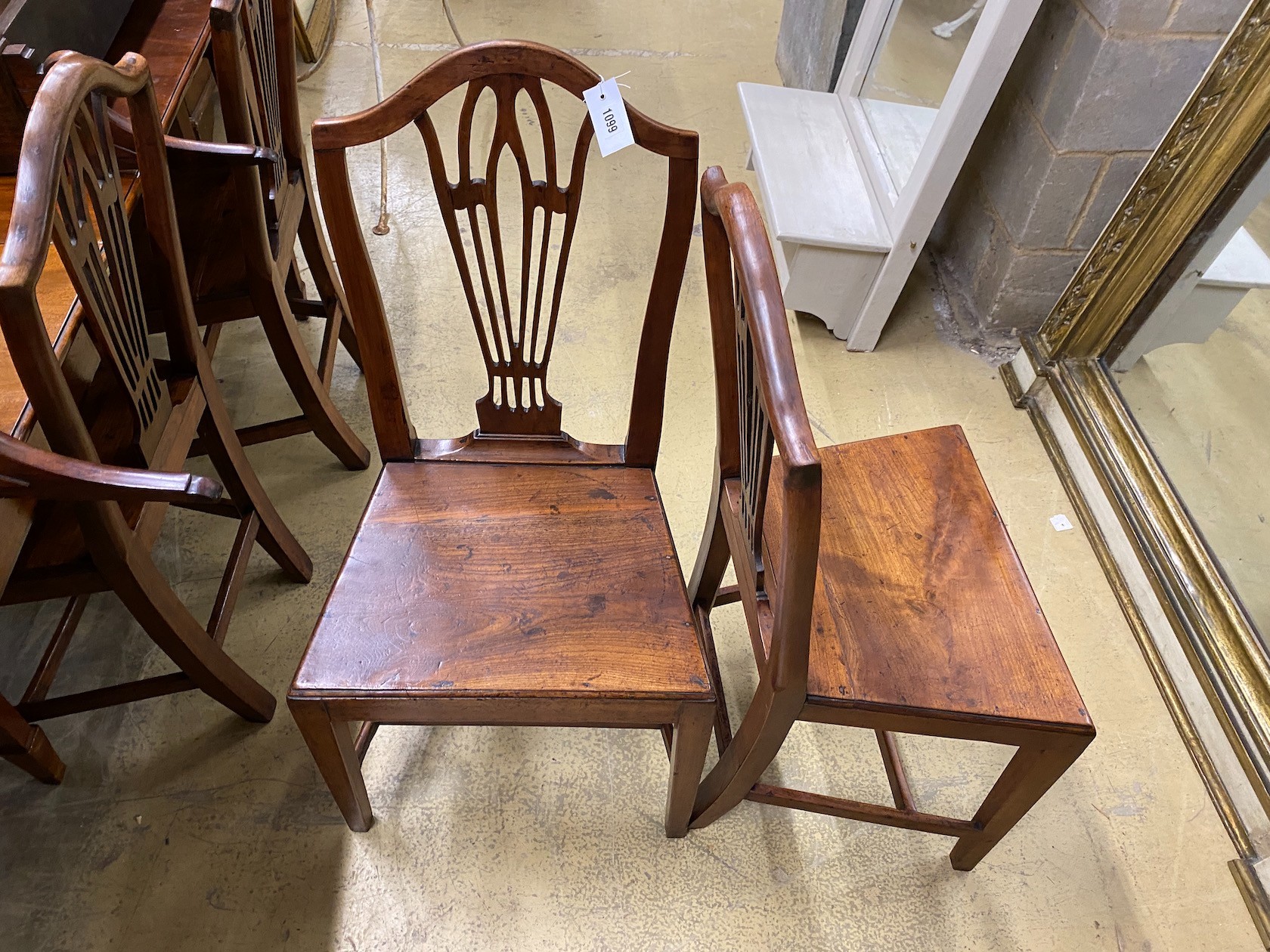 A set of four George III Provincial fruit wood solid seat dining chairs